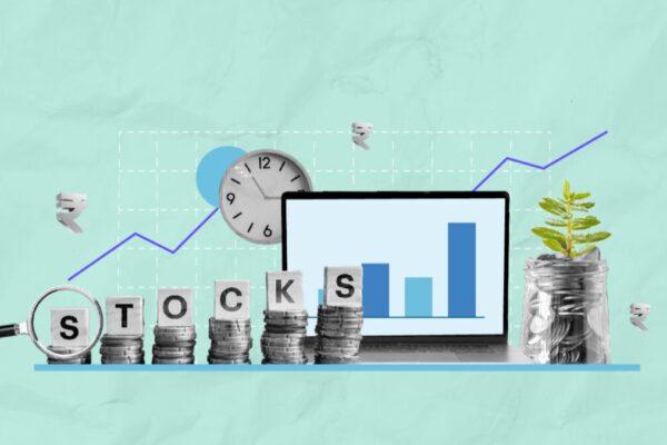 a laptop with stacks of coins and a clock depicting investment strategy