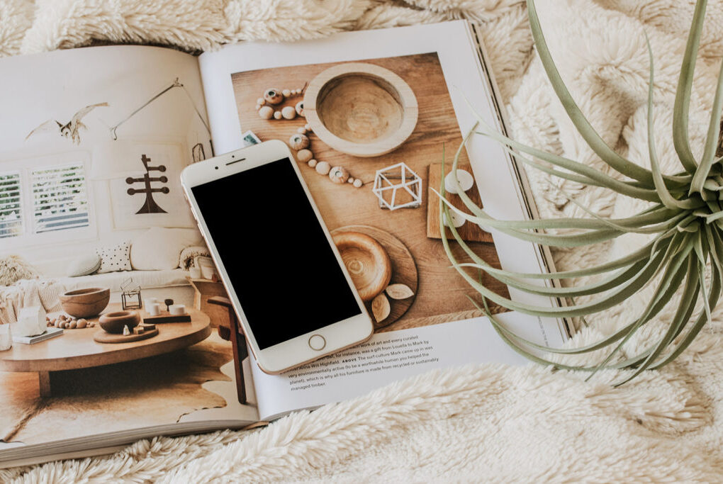 a smartphone on a book showing organized furniture indicating budgeting apps