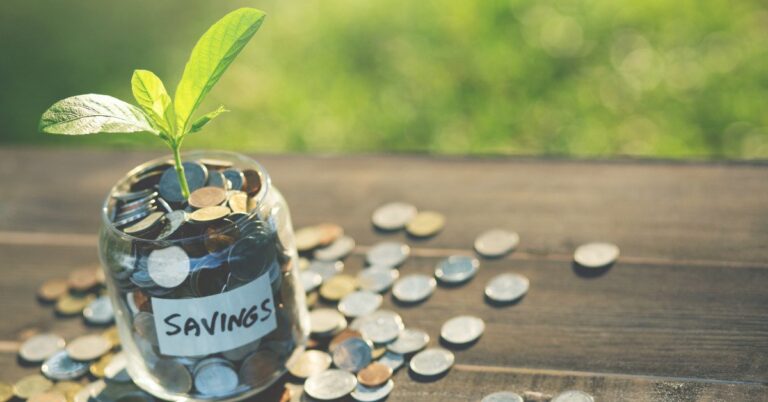 a jar of coins with a plant growing out of it