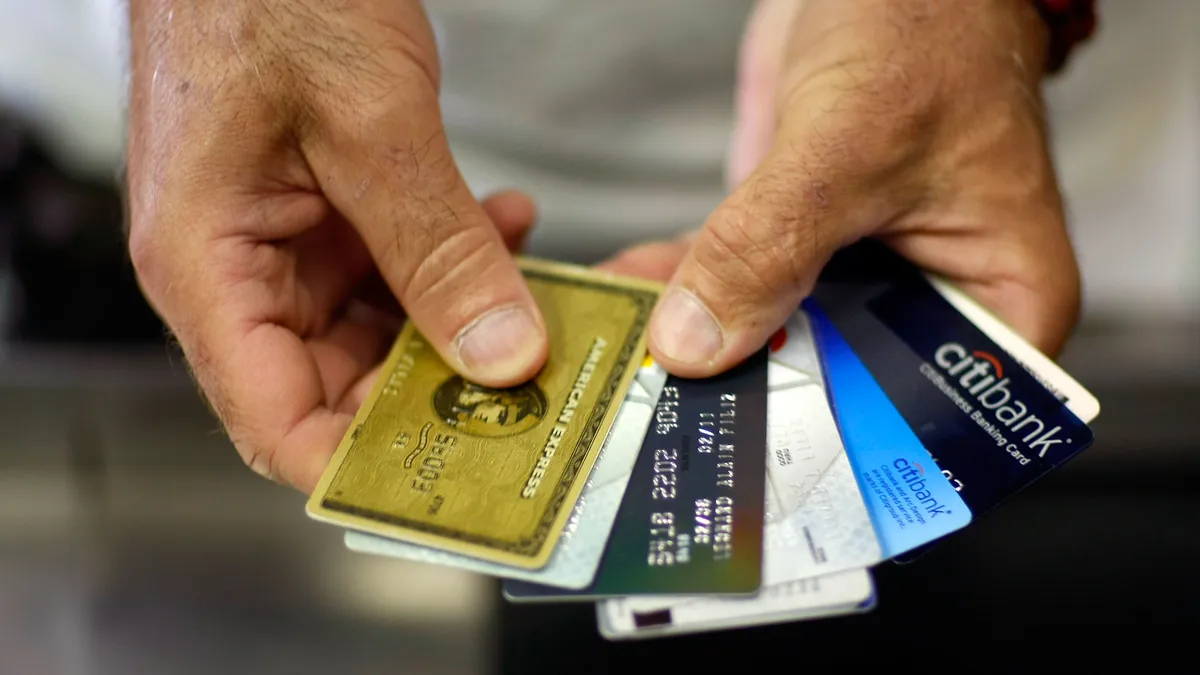 a person holding credit cards indicating credit card rewards